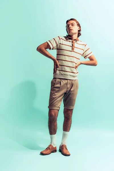 ライトブルーのスタジオを背景に隔絶されたレトロスタイルの衣装を着た若い男の完全な長さの肖像 レトロなファッション ファッション ライフスタイル 感情の概念 広告のコピースペース — ストック写真