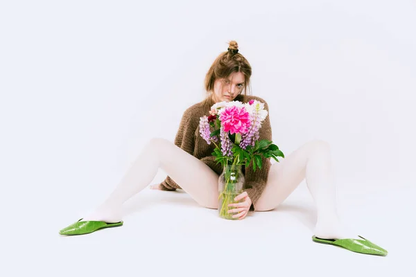 Fiatal Lány Túlméretezett Pulóverben Fehér Harisnyában Virágokkal Elszigetelt Szürke Stúdió — Stock Fotó