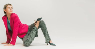 Gri stüdyo arka planında izole edilmiş şık, klasik giysiler içinde kısa saçlı güzel bir genç kızın portresi. Eski moda kavramı, sanat fotoğrafçılığı, stil, nonoş, güzellik, reklam. El ilanı