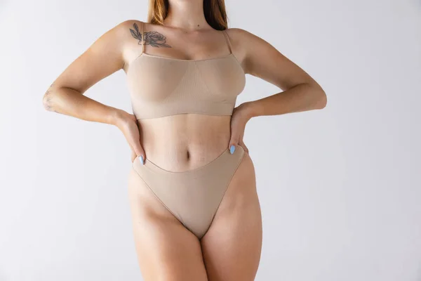 灰色のスタジオの背景に隔離された綿ベージュの下着で自然な外観の女性の体のトリミング画像 自己愛 ボディ スキンケア スパンクス シェイプウェア 化粧品 広告の概念 — ストック写真
