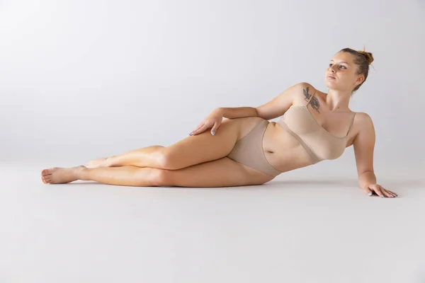 Ung Vacker Kvinna Liggande Golvet Poserar Bekväma Underkläder Isolerade Över — Stockfoto