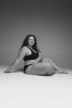 İç çamaşırlarıyla poz veren güzel bir kadının portresi. Siyah beyaz fotoğrafçılık. Vücut pozitifliği. Güzellik, vücut ve cilt bakımı, sağlık, estetik cerrahi, kozmetik, sağlık, reklam