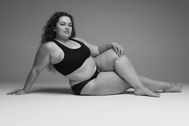 İç çamaşırlarıyla poz veren güzel bir kadının portresi. Siyah beyaz fotoğrafçılık. Kişisel bakım, kendini kabullenme. Güzellik, vücut ve cilt bakımı, sağlık, estetik cerrahi, ilaç, kozmetik, reklam