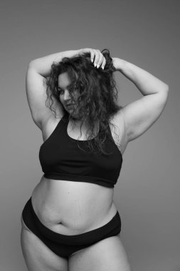 İç çamaşırlarıyla poz veren güzel bir kadının portresi. Siyah beyaz fotoğrafçılık. Kendini kabullenme. Güzellik kavramı, vücut ve cilt bakımı, sağlık, estetik cerrahi, kozmetik, reklam. Vücut pozitifliği