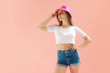 Pembe güneş gözlüklü ve panamalı güzel bir genç kızın portresi pembe stüdyo arka planında izole edilmiş poz veriyor. Mutluyum. Yaz kavramı, yaşam tarzı, gençlik, duygular, yüz ifadesi, reklam