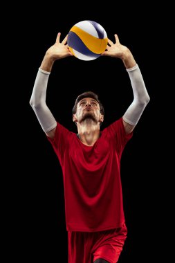 Genç bir adamın portresi, hareket halindeki voleybol oyuncusu, antrenman yapan, parmakları siyah stüdyo arka planında izole bir şekilde topa vuran. Spor, eylem, takım oyunu, aktif yaşam tarzı, sağlık, hobi, reklam