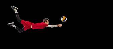 Genç bir adamın portresi, hareket halindeki voleybol oyuncusu, antrenman, siyah stüdyo arka planında soyutlanmış bir şekilde oynamak. Spor, aksiyon, takım oyunu, aktif yaşam tarzı, sağlık, hobi, reklam. Broşür resmi