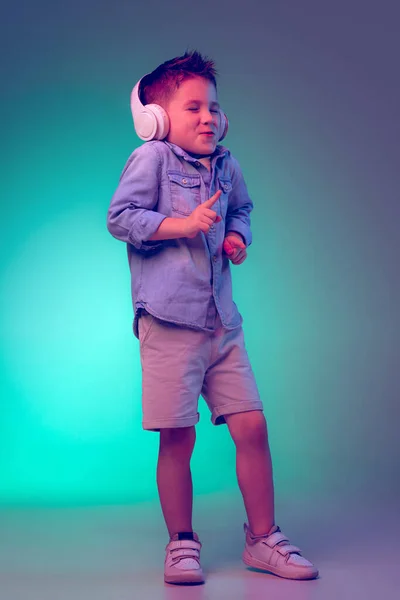 Portrait Little Boy Child Listening Music Headphones Posing Isolated Green — Stockfoto