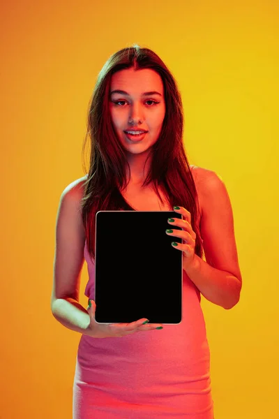 Portrait Beautiful Young Girl Posing Tablet Isolated Yellow Background Neon —  Fotos de Stock