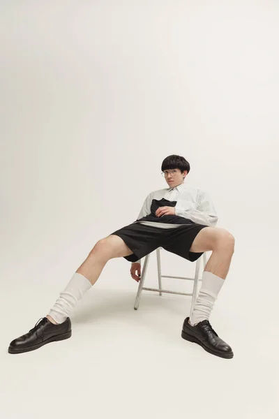 Portrait Stylish Young Boy Sitting Chair Posing Isolated Grey Studio — Zdjęcie stockowe