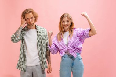 Portrait of young man and woman in casual clothes posing isolated over pink studio background. Happy and thoughtful look. Concept of youth, lifestyle, relationship, emotions, facial expression, ad
