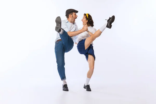 Portrait of young emotive couple, man and woman, dancing boogie woogie isolated over white background. Excitement . Concept of vintage fashion, hobby, activity, art, music, party, creativity and ad