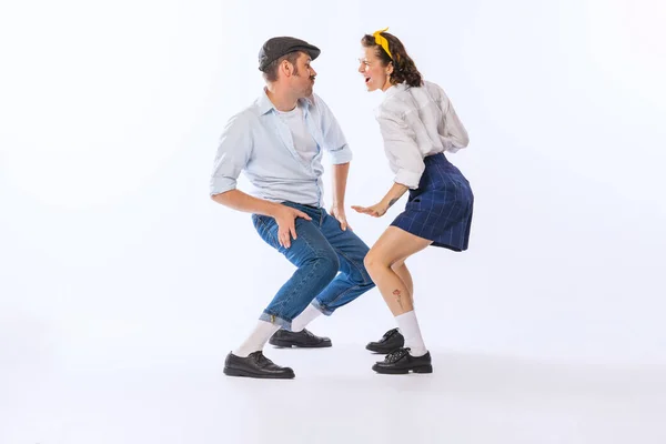 Portrait of young emotive couple, man and woman, dancing retro dance isolated over white background. Funny faces. Concept of vintage fashion, hobby, activity, art, music, party, creativity and ad