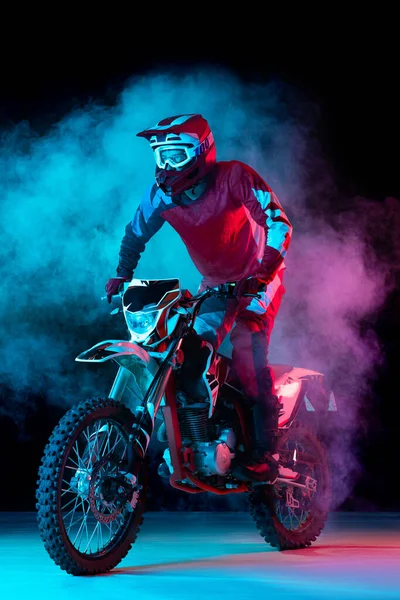 Portret Młodego Człowieka Motocyklista Stojący Motocyklu Odizolowany Ciemnym Tle Neonowym — Zdjęcie stockowe