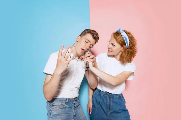 Portrait Young Emotive Couple Singing Microphone Karaoke Isolated Pink Blue — Zdjęcie stockowe
