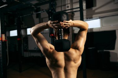 Kaslı erkek vücudunun arka plan görüntüsü, geriye ve ellere ait doku. Dambılla el ve sırt egzersizi yapan genç bir sporcu. Spor, sağlık, eylem, beslenme, gençlik kavramı. İlan için alanı kopyala