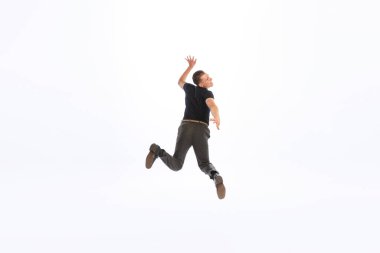 Beyaz stüdyo arka planında izole edilmiş siyah kıyafetli bir gencin portresi. Etkileyici komik atlayış. Eski moda kavramı, gençlik, yaşam tarzı, duygular, ifade. İlan için alanı kopyala