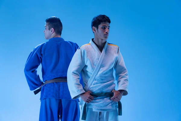 Portrait Two Young Sportive Men Posing Kimono Isolated Blue Studio — Zdjęcie stockowe