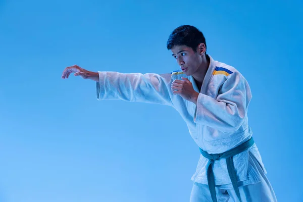 Portrait Young Sportive Man Posing Training Punch Exercises Isolated Blue — ストック写真