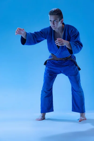 Portrait Young Sportive Man Posing Position Punch Isolated Blue Studio — Φωτογραφία Αρχείου