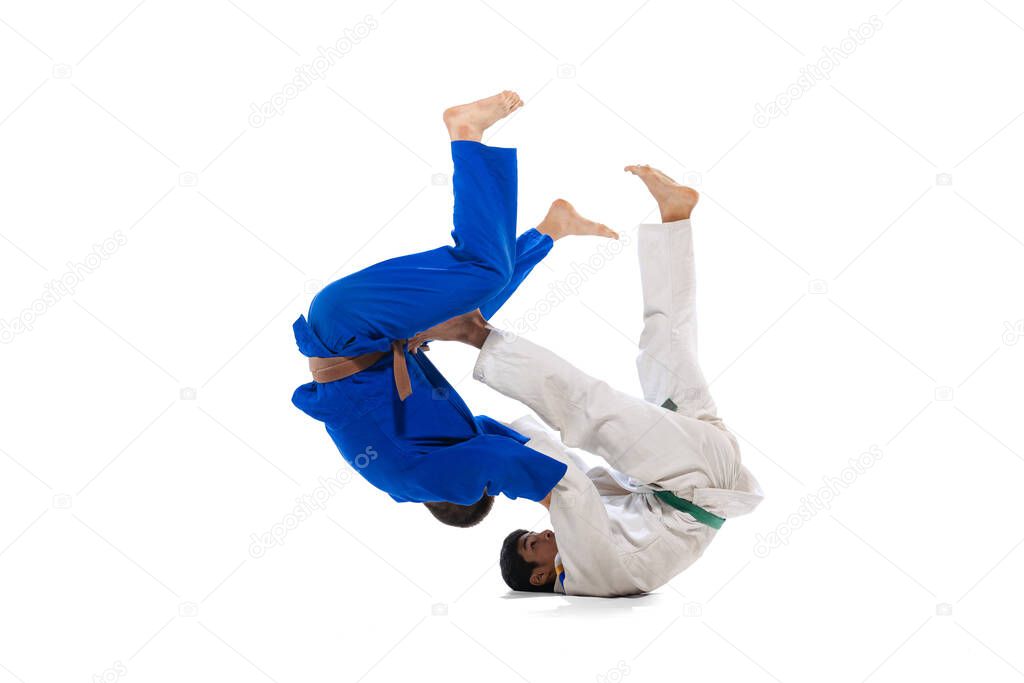Forward Roll Breakfall. Studio shot of two men, professional judo athletes training isolated on white background. Concept of martial art, combat sport, health, strength, energy, fit. Copy space for ad