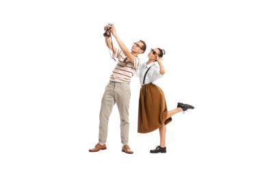 Portrait of man and woman posing, taking selfie with vintage camera isolated on white background. Retro style. Concept of relationship, love, travelling, lifestyle, success, ballet, expression, ad