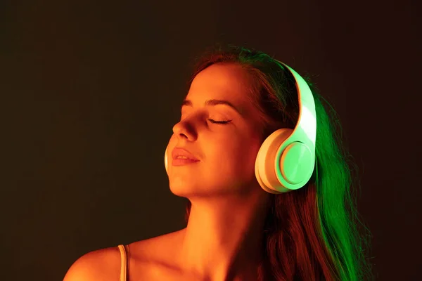 Portrait Young Woman Listening Music Headphones Isolated Brown Background Neon — Stock fotografie