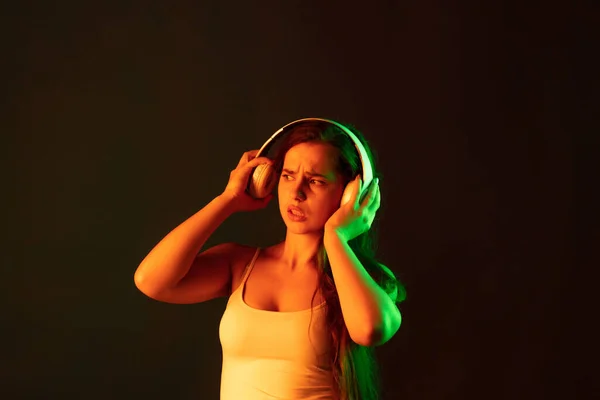Portrait Emotive Young Woman Headphones Posing Brown Background Neon Light —  Fotos de Stock