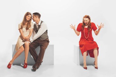 Portrait of young angry girl finding out man cheating her with another woman. Unfaithful relationship. Concept of retro fashion, style, youth culture, emotions, relationship, ad