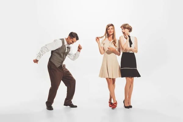 Portrait of stylish people in vintage clothes, man and women at the party, dancing, talking, posing isolated on white background. Concept of retro fashion, style, youth culture, emotions, beauty, ad
