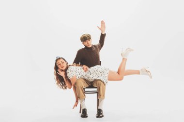 Portrait of young man and woman, couple posing isolated over white studio background. Relationship quarrels. Concept of retro fashion, style, youth culture, emotions, beauty, ad