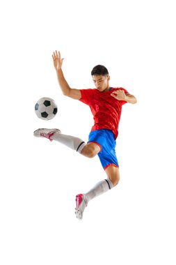 Portrait of young man, football player in motion, training, kicking ball in a jump isolated over white studio background. Concept of sport, team game, action, motion. Copy space for ad, poster