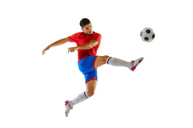 Portrait of young man in uniform, professional football player kicking ball in a jump isolated over white studio background. Concept of sport, team game, action, motion. Copy space for ad, poster