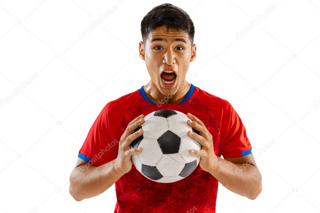 Portrait of young emotive man, football player in red uniform posing with ball isolated over white studio background. Concept of sport, team game, action, motion. Copy space for ad, poster