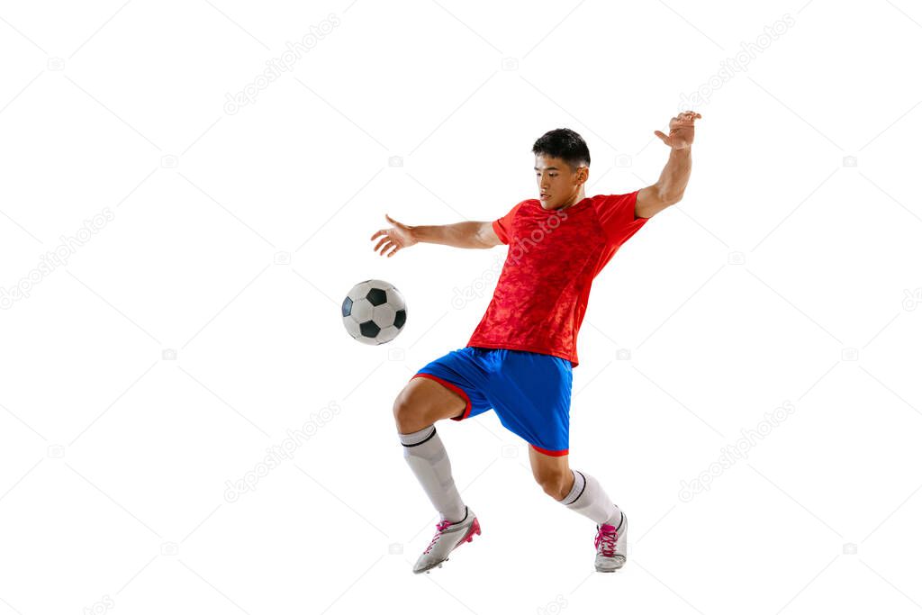 Portrait of young man, football player training, playing, kicking ball isolated over white studio background. Professional. Concept of sport, team game, action, motion. Copy space for ad, poster