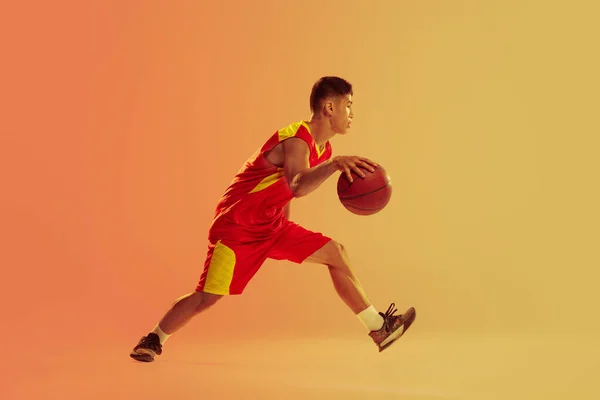 Динамичный Портрет Молодого Человека Баскетболист Движении Дриблинг Изолирован Фоне Оранжевой — стоковое фото