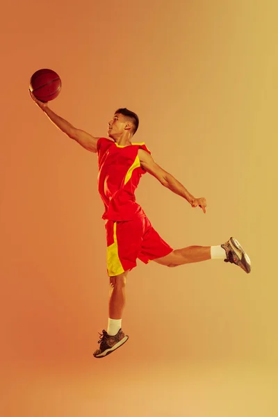 Портрет Молодого Человека Баскетболиста Изолированного Фоне Оранжевой Студии Неоновом Свете — стоковое фото