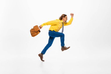 Portrait of man, office worker in colorful clothes with briefcase running to work. Concentrated and motivated employee. Concept of human emotion, office, success, career, expression. Copy space for ad