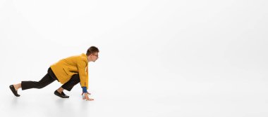 Portrait of young concentrated man, office worker standing on starting line and ready to run isolated on white background. Motivation. Concept of human emotions, office, success, career, expression.