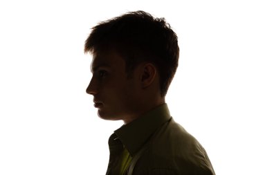 Side view portrait of young man looking away isolated over white studio background. Silhouette. Concept of emotions, facial expression, lifestyle, fashion, youth