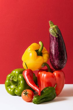 Set of healthy fresh vegetables. Red, green, yellow peppers, chili, tomatoes and eggplant isolated over red background. Vitamins. Concept of grocery, nutrition, taste, health. Colorful image