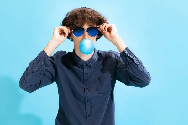 Portret Młodego Mężczyzny Okularach Pozujących Gumą Balonową Wyizolowaną Tle Niebieskiego — Zdjęcie stockowe