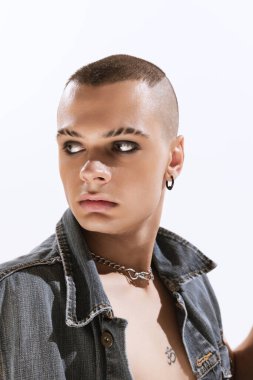 Beyaz arka planda izole edilmiş siyah kot gömlekle poz veren dumanlı gözlü genç adam portresi. Moda kavramı, seçim özgürlüğü, yaşam tarzı, lgbt, Z nesli, trendler