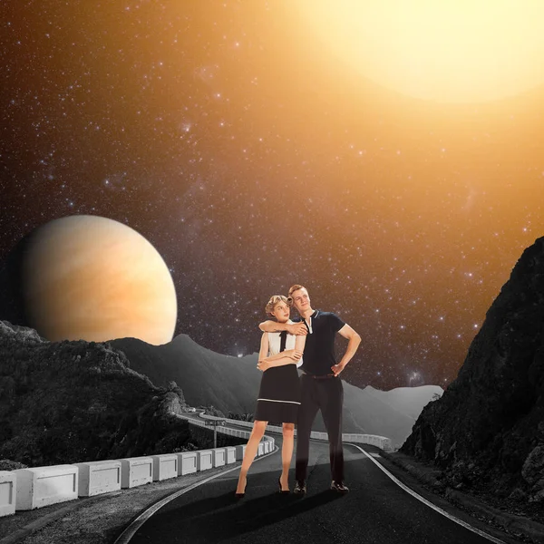 Contemporary art collage. Young couple standing on the road near mountain cliff over starry night with big planets and sun. Concept of surreal design, creativity, love, relationship, nature