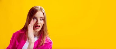 Genç ve güzel bir kadının portresi. Stüdyonun sarı arka planında gizlice konuşuyordu. Güzellik anlayışı, yaşam tarzı, gençlik, duygular, yüz ifadesi, reklam. İlan için alanı kopyala