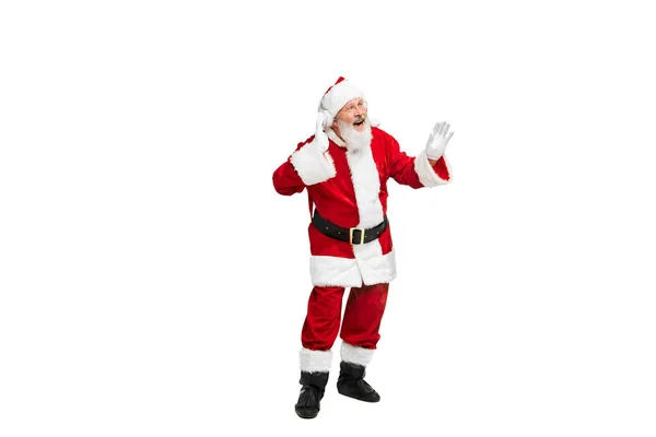 白い背景の上に隔離されたヘッドフォンで音楽を聴くサンタクロースのイメージの高齢者の肖像画 架空の人物 クリスマスの概念 広告のコピースペース — ストック写真