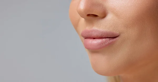 在灰色背景下孤立的丰满女性唇的特写图像 化妆品注射 唇隆起 自然肌肤 塑料糖的概念 广告的复制空间 — 图库照片