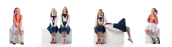 漂亮少女的画像 穿着校服的孩子们坐在那里 在白色的工作室背景上摆出孤立无援的姿势 童年的概念 孩子的时尚 生活方式 广告的复制空间 — 图库照片
