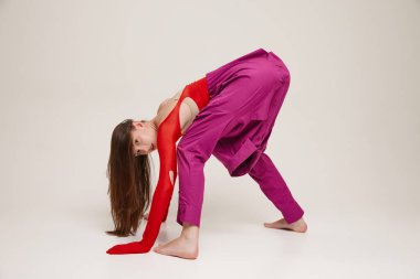 Gri arka planda pantolon ve tayt yerine gömlek giyen güzel bir kızın portresi. Eski moda kavramı, sanat fotoğrafçılığı, stil, nonoş, güzellik, reklam.