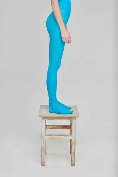 Imagen Recortada Mujer Mallas Azules Pie Silla Aislada Sobre Fondo — Foto de Stock